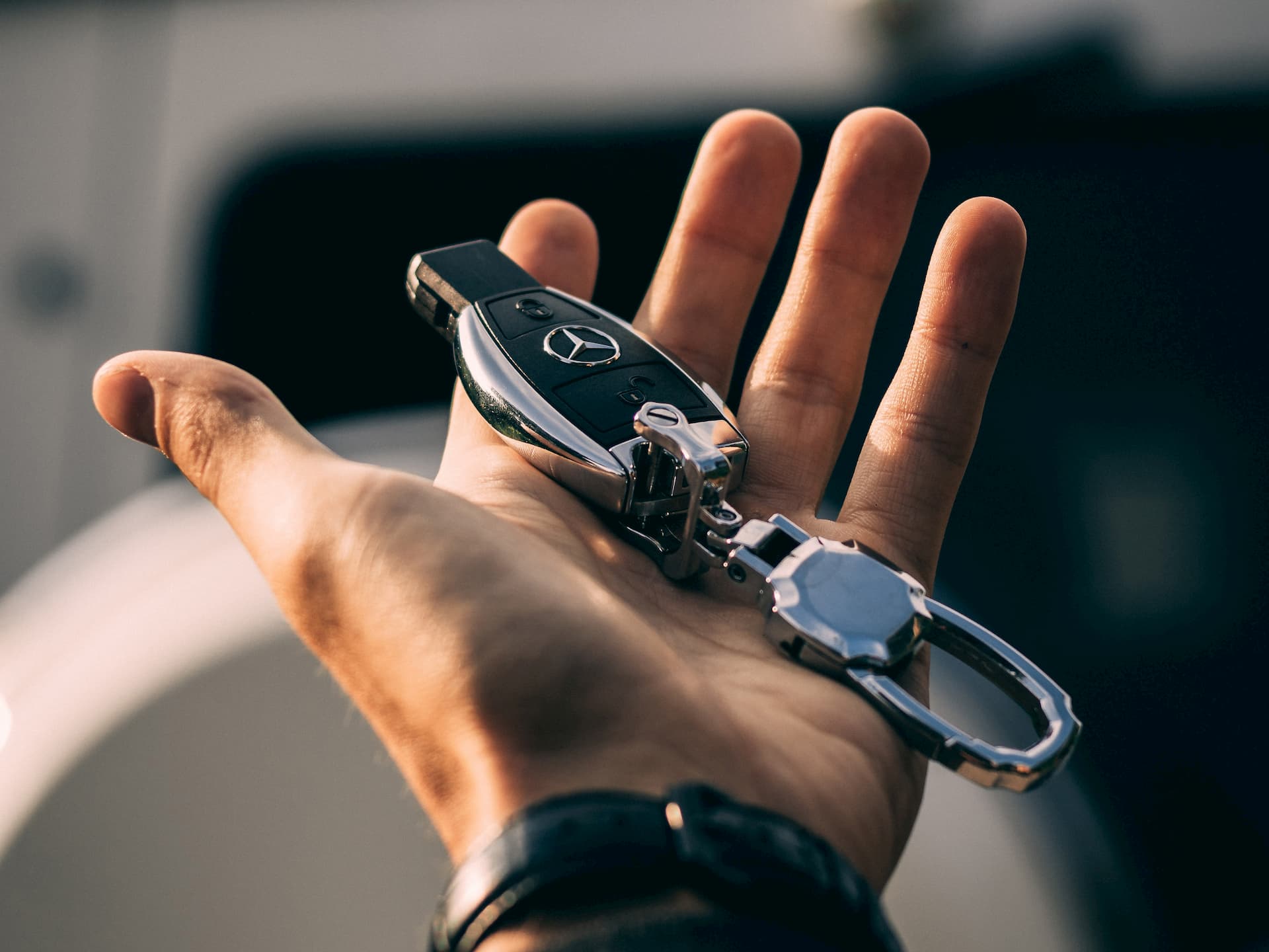 Hand Stretched Out Holding Mercedes-Benz Car Key